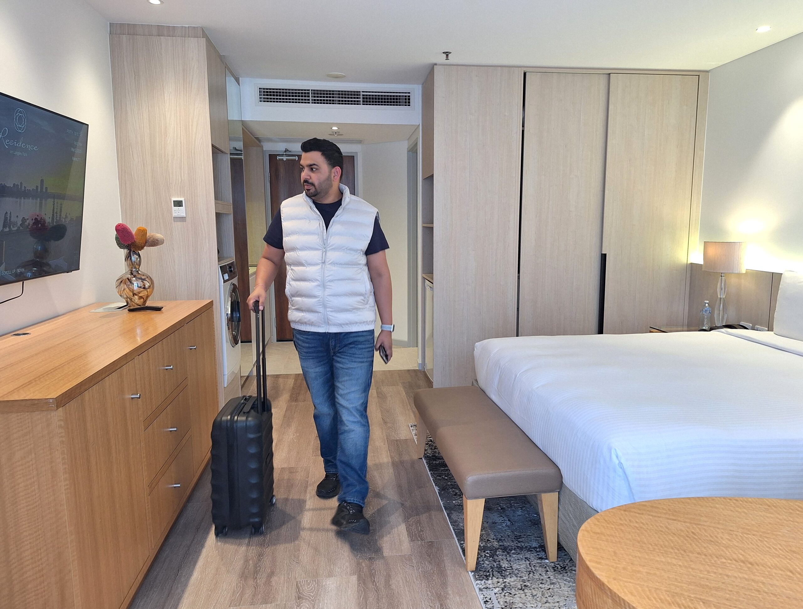 A person arrives at the hotel carrying a trolley