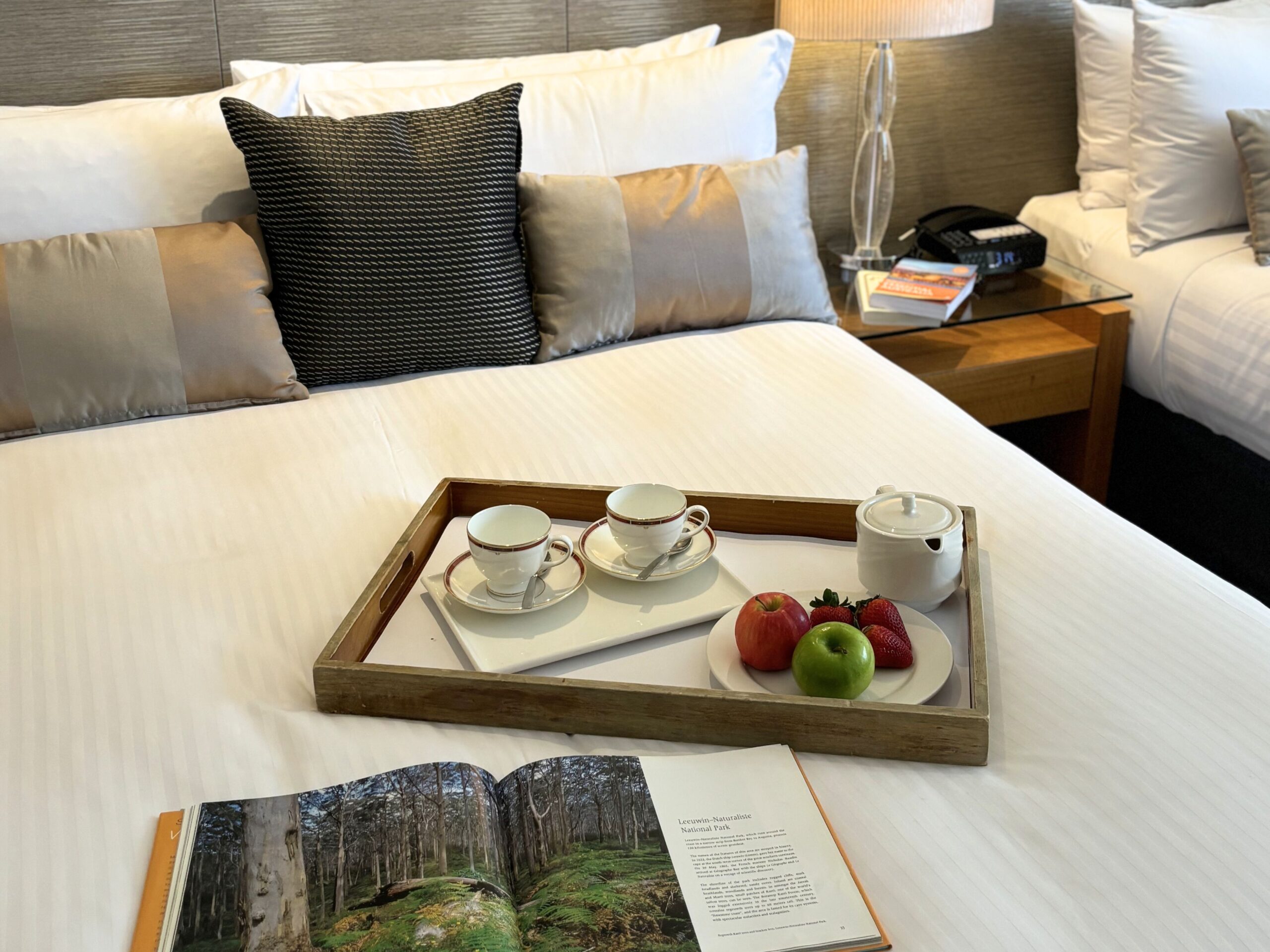 Queen bed with a cup and an apple
